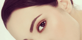 Close-up image of a woman's eyebrows with hairline microblading, showing fine, natural-looking hair strokes.