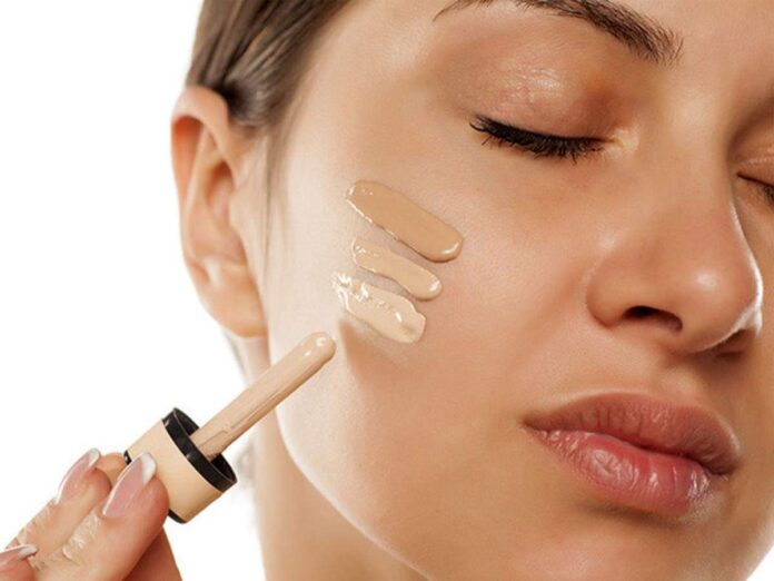 Image of a woman's face with flawless skin and a foundation brush.