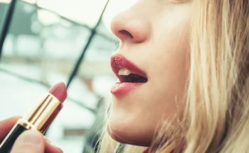 A woman's lips adorned with perfectly applied red lipstick, showcasing professional makeup techniques.
