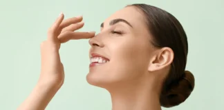 A woman gently applying a natural moisturizer to her face. The focus is on her hands and the moisturizer, emphasizing a skincare routine for oily skin using natural products.