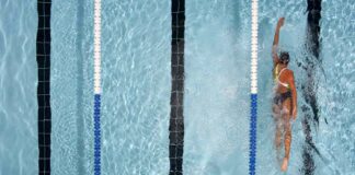 A person engaged in a swimming weight loss workout, swimming laps in a pool with focused determination.