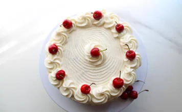 Delicious white chocolate cake with creamy frosting on a platter.