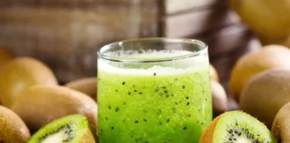Refreshing kiwi lemonade served in a glass with slices of fresh kiwi and lemon on the rim.