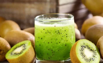 Refreshing kiwi lemonade served in a glass with slices of fresh kiwi and lemon on the rim.