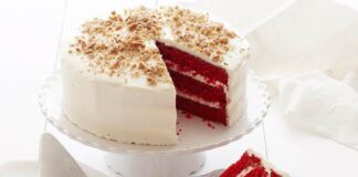 Delicious homemade red velvet cake topped with creamy frosting and chocolate shavings, perfect for birthdays and special occasions.