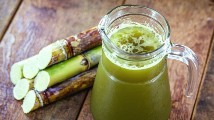 Refreshing sugarcane juice served in a glass with a slice of lime - a delicious and natural beverage recipe for a hot summer day