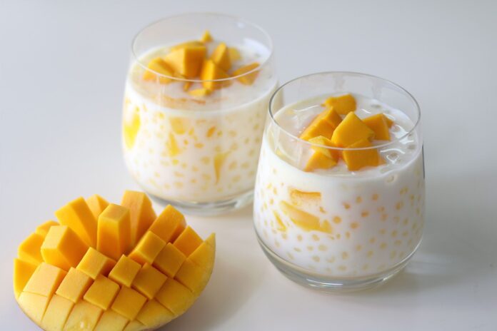 Delicious homemade creamy mango sago dessert served in a glass, featuring fresh mango chunks and tapioca pearls in a rich, creamy coconut milk base. Perfect summer treat for mango lovers!