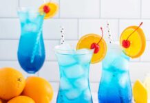 Refreshing Blue Lagoon Mocktail recipe: A tropical-inspired beverage with a vibrant blue hue, combining lemonade, pineapple juice, and a hint of coconut cream, garnished with fresh fruit and served over ice. Perfect for summer parties or non-alcoholic gatherings.