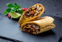 Delicious homemade chicken burrito with seasoned chicken, rice, beans, and fresh vegetables wrapped in a warm tortilla.